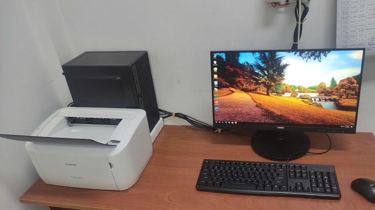 Máy in laser và máy tính tại bàn làm việc văn phòng